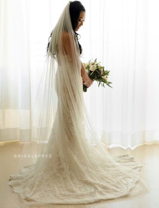 Bride wearing lace mermaid dress with Bridal Spree's ivory long soft chapel veil